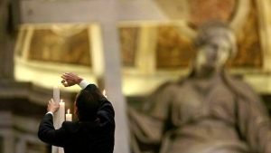 Si arrampica sul campanile della chiesa e lancia mattoni contro le persone