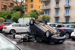 Incidente sulla Tuscolana: auto si ribalta, scooterista scivola sull'asfalto per evitarla. Due feriti