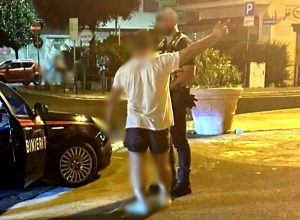 Rovescia bidoni e lancia bottiglie contro le auto