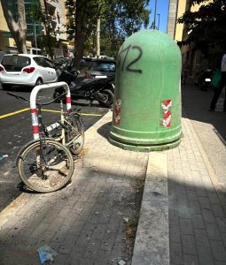 La campana per il vetro spostata e abbandonata sulla rampa per disabili