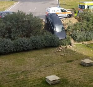 Auto abbatte il muretto e resta in bilico